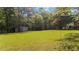 A metal shed in the middle of a spacious green yard surrounded by several trees at 413 Bayles Rd, Lillington, NC 27546