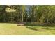 Exterior shot of a yard with a built-in stone picnic table under the shade of the trees at 413 Bayles Rd, Lillington, NC 27546