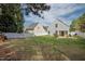 A view of the house and fenced backyard, showing the green lawn, white fence, and neighboring home at 4414 Nightfall Ct, Durham, NC 27713