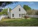 View of the home's back exterior with a charming white picket fence and well-manicured lawn at 4414 Nightfall Ct, Durham, NC 27713
