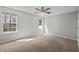 Spacious bedroom with neutral carpet, two windows offering ample natural light, and ceiling fan at 4414 Nightfall Ct, Durham, NC 27713