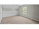 A bright bedroom with white wainscoting and a window showing the exterior at 4414 Nightfall Ct, Durham, NC 27713