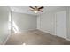 Carpeted bedroom featuring a ceiling fan, natural light, and ample closet space at 4414 Nightfall Ct, Durham, NC 27713