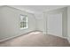 Sunlit bedroom featuring neutral carpet, a window and a double-door closet at 4414 Nightfall Ct, Durham, NC 27713