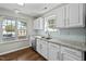Clean kitchen featuring stainless steel appliances, granite countertops, and hardwood floors with a view from two windows at 4414 Nightfall Ct, Durham, NC 27713