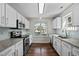 Bright kitchen with white cabinets, granite countertops, stainless steel appliances, and a window over the sink at 4414 Nightfall Ct, Durham, NC 27713