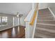 Inviting living room with hardwood floors and a staircase featuring a light-stained wood banister at 4414 Nightfall Ct, Durham, NC 27713