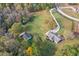 Aerial showcasing a spacious lot with the main house, garage and wooded perimeter at 460 Mann Rd, Coats, NC 27521