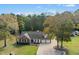 Sprawling home showcases a spacious lot with mature trees, a long driveway, and an attached two-car garage at 460 Mann Rd, Coats, NC 27521