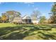 A spacious backyard featuring a large lawn, mature trees, a screened porch, and a deck area at 460 Mann Rd, Coats, NC 27521