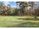 A large backyard featuring mature trees and a long view of the wooded area at 460 Mann Rd, Coats, NC 27521