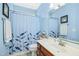 Bathroom with blue walls, vanity, mirror, and shower curtain at 460 Mann Rd, Coats, NC 27521