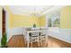 Dining room featuring wood floors, wainscoting, bright yellow walls, and a chandelier at 460 Mann Rd, Coats, NC 27521