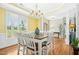 Open dining room features wood floors, crown molding, a chandelier, and large windows at 460 Mann Rd, Coats, NC 27521