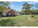Expansive front yard with mature trees frames this home's charming exterior appeal at 460 Mann Rd, Coats, NC 27521