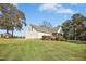 Exterior of home with large grassy yard and wooded background at 460 Mann Rd, Coats, NC 27521
