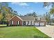 Charming brick home featuring a manicured front lawn, a two-car garage and inviting front porch at 460 Mann Rd, Coats, NC 27521