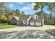 Charming brick and siding home featuring a two-car garage and covered front porch at 460 Mann Rd, Coats, NC 27521