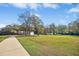 A wide front yard featuring mature trees, a house with a long driveway and a detached garage at 460 Mann Rd, Coats, NC 27521