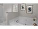 This bright bathroom features a large white bathtub and modern fixtures at 4720 Brigadoon Dr, Durham, NC 27705