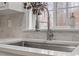 Modern kitchen sink with stainless steel faucet and tiled backsplash near window offers plenty of natural light at 4720 Brigadoon Dr, Durham, NC 27705