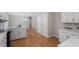 Bright kitchen with white cabinets, hardwood floors, and a seamless connection to other living areas at 4720 Brigadoon Dr, Durham, NC 27705