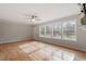 Spacious living room with hardwood floors, a ceiling fan, and multiple windows providing natural light at 4720 Brigadoon Dr, Durham, NC 27705