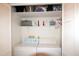 Laundry closet with a stacked washer and dryer and shelf storage at 502 W Poplar Ave # C2, Carrboro, NC 27510