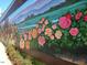 Charming mural featuring colorful flowers along a landscape scene at 502 W Poplar Ave # C2, Carrboro, NC 27510