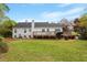 Rear exterior of house with lawn, deck, patio, and mature trees at 5212 Theys Rd, Raleigh, NC 27606