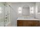 Modern bathroom features double vanity with ample lighting, a walk-in shower and clean lines at 5212 Theys Rd, Raleigh, NC 27606