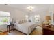 Bright bedroom featuring a large bed, natural light, and neutral decor at 5212 Theys Rd, Raleigh, NC 27606