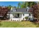 Charming white brick home with a welcoming front porch and beautifully landscaped front yard at 5212 Theys Rd, Raleigh, NC 27606