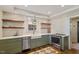 Updated kitchen boasts stainless steel appliances, white subway tile, farmhouse sink, and floating shelves at 5212 Theys Rd, Raleigh, NC 27606