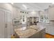 Contemporary kitchen featuring an island with a sink, stainless steel hood, and plentiful storage at 5212 Theys Rd, Raleigh, NC 27606