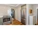 Kitchen with stainless steel refrigerator and stove, light wood flooring, and view to entry at 5212 Theys Rd, Raleigh, NC 27606