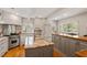 Well-lit kitchen with granite countertops, stainless steel appliances, and custom cabinetry at 5212 Theys Rd, Raleigh, NC 27606