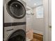 Modern laundry area with stacked washer/dryer, shelving, and natural light at 5212 Theys Rd, Raleigh, NC 27606