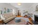 Bright living room featuring a fireplace, light-colored sofa and a decorative area rug at 5212 Theys Rd, Raleigh, NC 27606