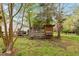 Backyard view of a chicken coop in a lush green landscape with mature trees at 5212 Theys Rd, Raleigh, NC 27606