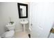 Half bath featuring a pedestal sink, toilet, and decorative mirror at 5403 Bayside Ct, Raleigh, NC 27613