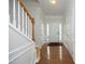 Bright foyer with hardwood floors, white wainscoting, and a staircase leading to the upper level at 5403 Bayside Ct, Raleigh, NC 27613