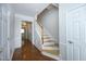 Hallway with light wood stairs, white banister, neutral walls, and doorways into other rooms at 5403 Bayside Ct, Raleigh, NC 27613