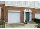 Home exterior featuring a brick facade, a single-car garage, and a green front door with decorative trim at 5403 Bayside Ct, Raleigh, NC 27613