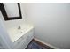 Well-lit half bathroom featuring a classic vanity with a mirror and a decorative blue rug at 5403 Bayside Ct, Raleigh, NC 27613
