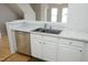 Kitchen sink with stainless steel dishwasher, white cabinets and marble countertops at 5403 Bayside Ct, Raleigh, NC 27613