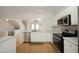 Well-lit kitchen featuring stainless steel appliances, white cabinets, and marble countertops at 5403 Bayside Ct, Raleigh, NC 27613