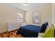 Well-lit bedroom features hardwood floors and a cozy blue quilted bedspread at 545 E Lenoir St, Raleigh, NC 27601