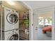 Bright laundry room with washer, dryer, shelving, and view to sun room at 545 E Lenoir St, Raleigh, NC 27601