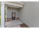 Covered entryway showing dark front door, stone accents, gray vinyl siding and white post at 601 Benton Dr, Oxford, NC 27565